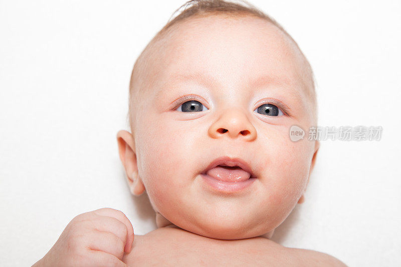 幸福的蓝眼睛婴儿脸在白色