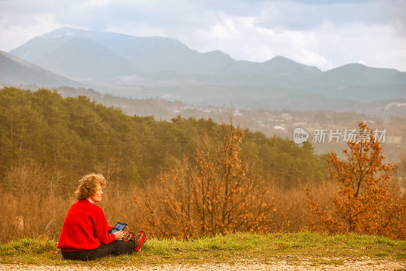 秋天的乡下，女人拿着平板电脑