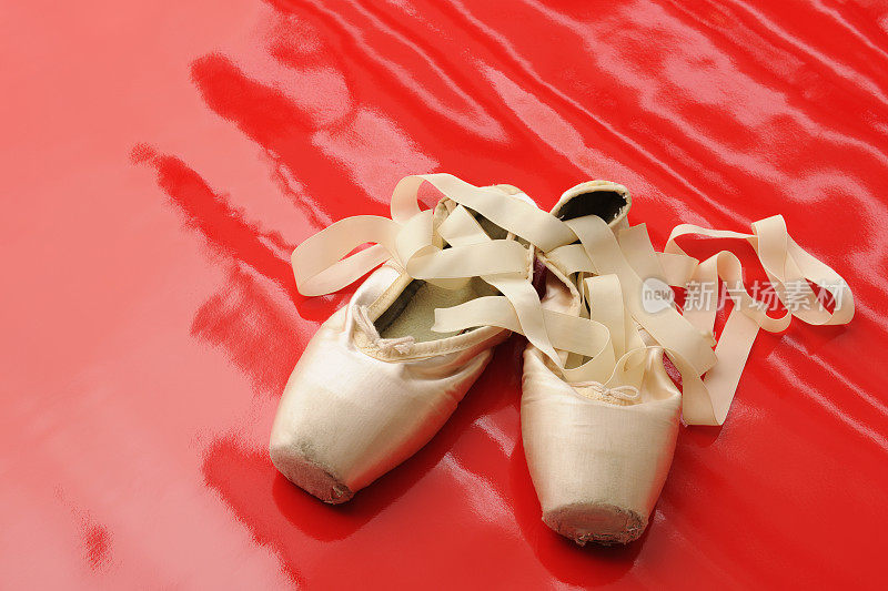 旧粉红缎古典芭蕾舞鞋上的红色闪亮乙烯基