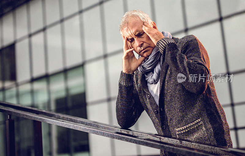 压力山大的成熟商人痛苦地抱着头。