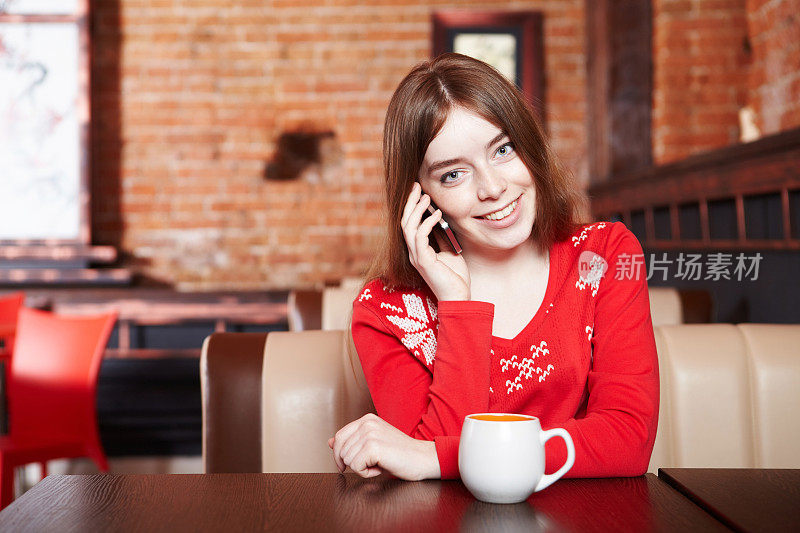 美丽的女孩在咖啡厅喝茶
