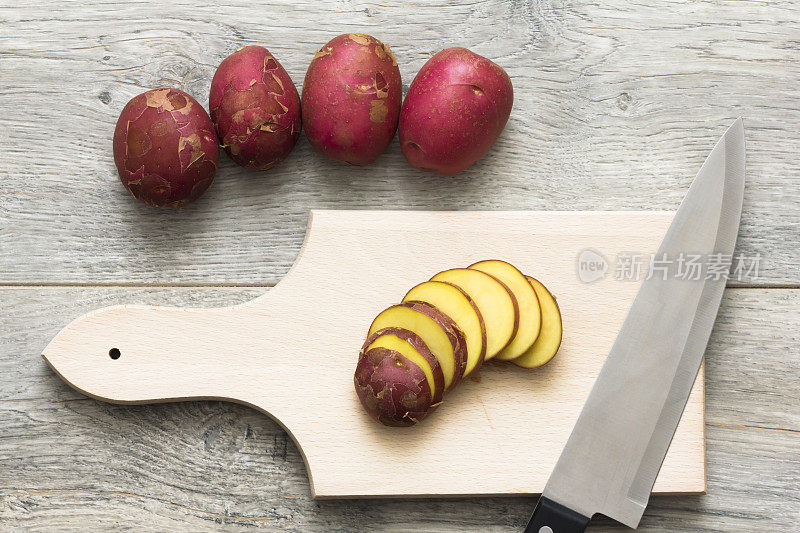 切好的红土豆放在厨房的木桌上。正上方的观点。