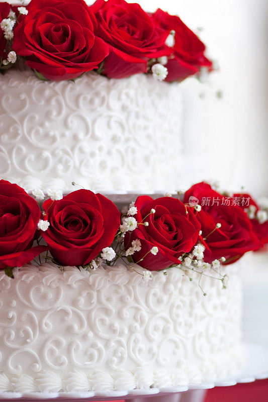 红玫瑰在白色婚礼蛋糕顶部近距离