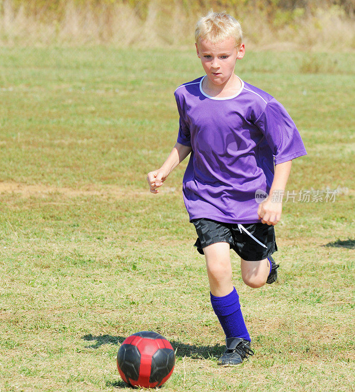 年轻男子足球运动员带球奔跑