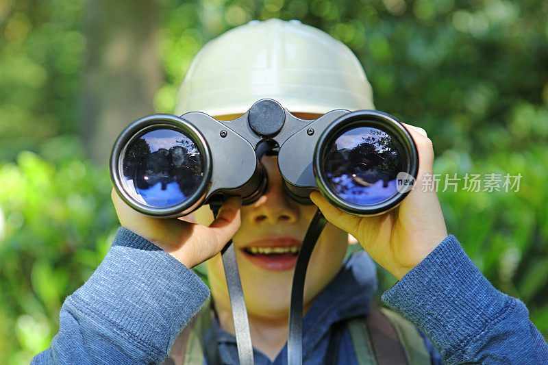 孩子与双筒望远镜和Safari帽特写