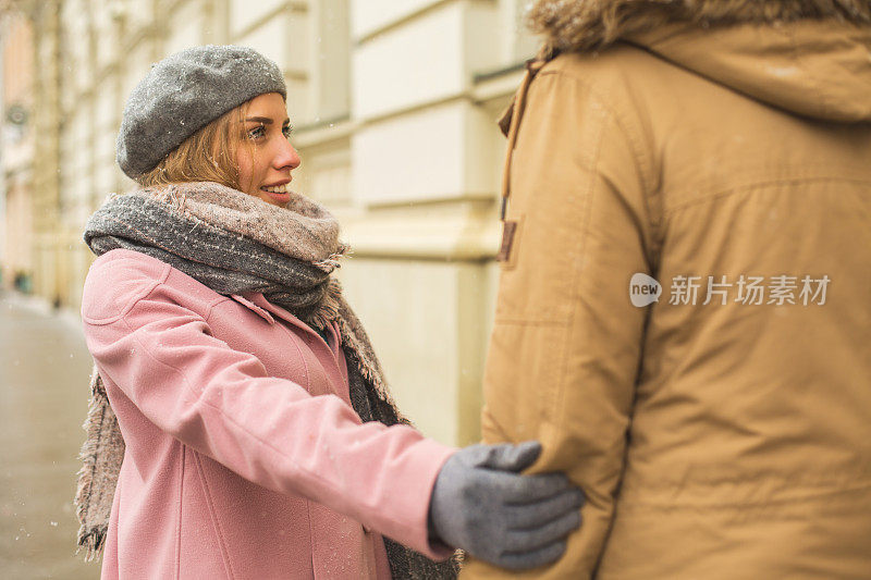 女人牵着男人的手走在街上