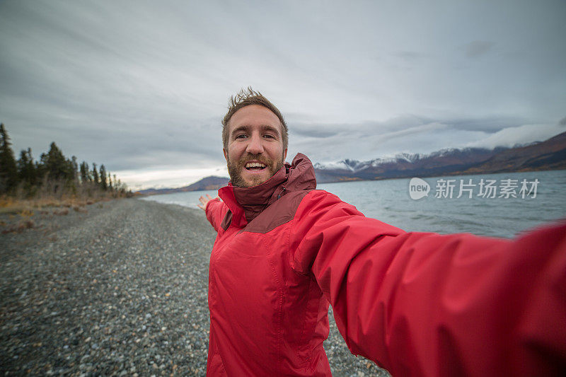 一名年轻人在湖边旅游自拍