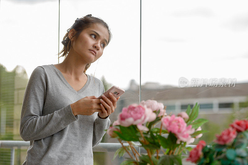 年轻美丽的亚洲女人在家里放松