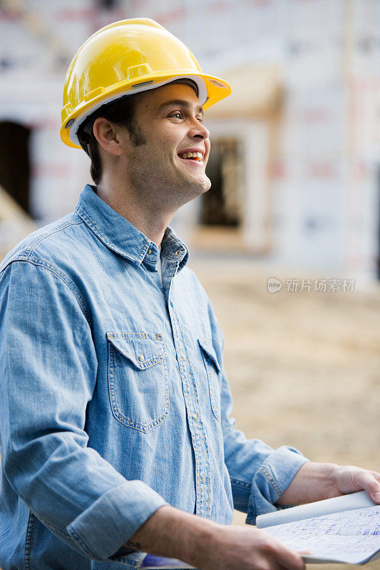 戴着安全帽拿着蓝图的建筑工人