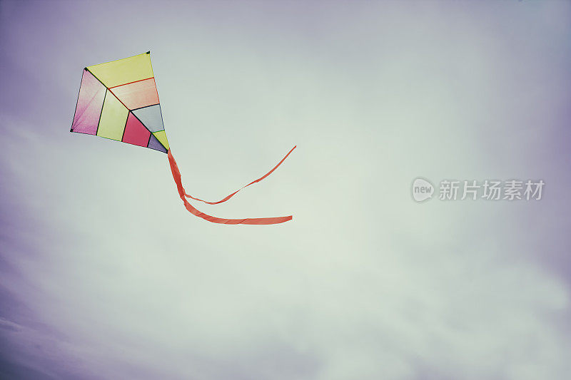 五颜六色的风筝飞着，挥舞着红色的蝴蝶结