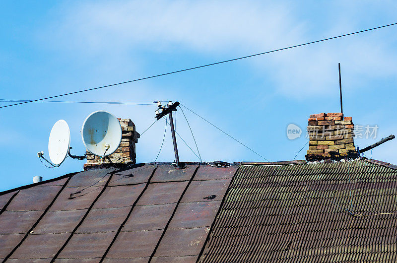 老房子的屋顶有烟囱和电视卫星天线