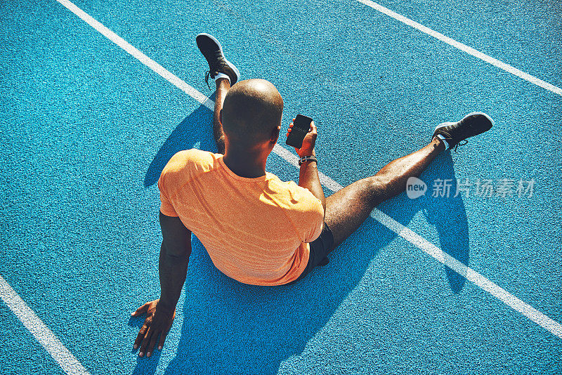 年轻的跑步者使用一个应用程序查看他的圈速