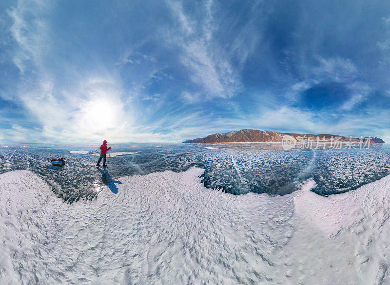 游客们乘坐雪橇沿着贝加尔湖的蓝冰漫步。广角全景