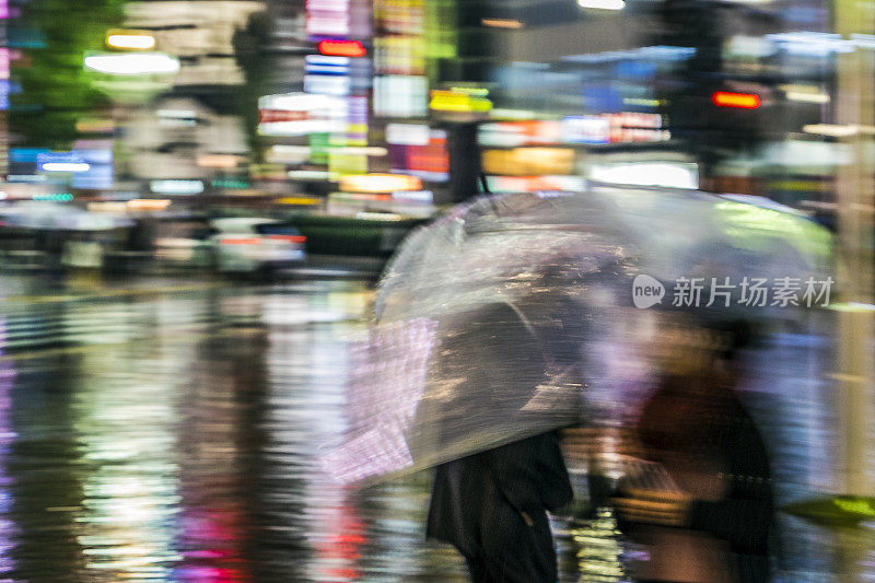 雨中的城市:在东京繁忙的街道上，人们在倾盆大雨中撑着雨伞