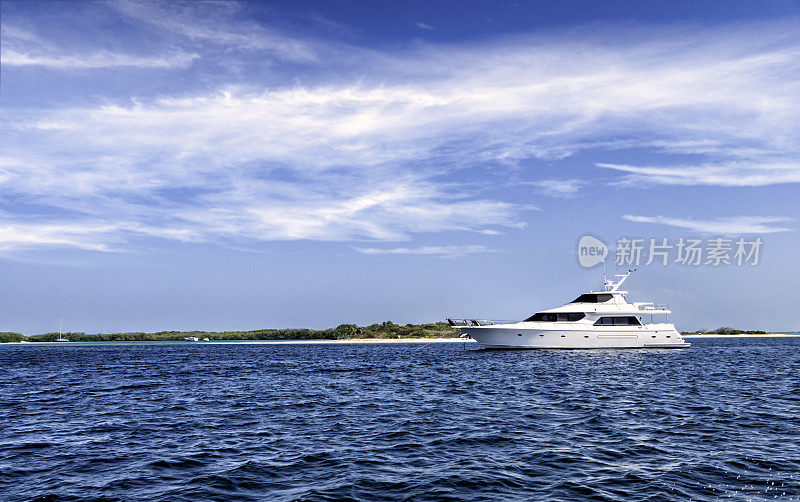 一艘豪华游艇停泊在热带岛屿的绿松石海滩上