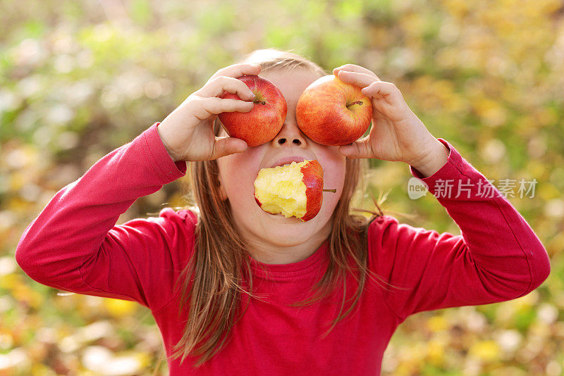在果园里吃苹果的女孩