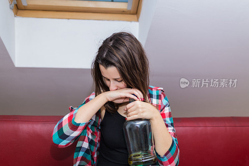 坐在沙发上的醉醺醺的年轻女人