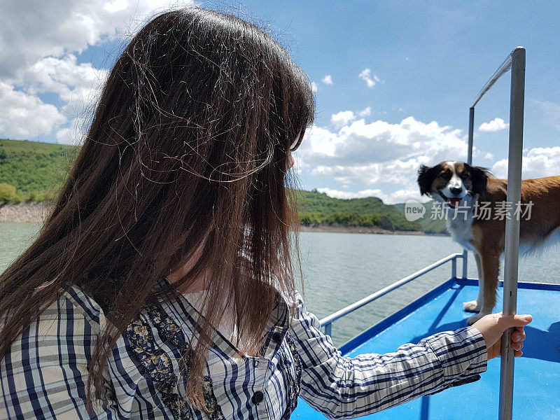 一个年轻女子和她的狗在小船上享受空闲时间。