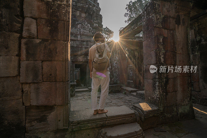 渴望旅游的年轻人探索古老的寺庙在日落在亚洲，吴哥窟-柬埔寨;人们旅行发现度假的概念