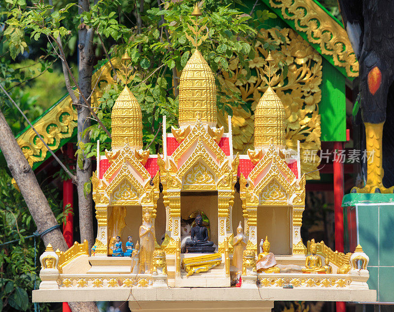 泰国寺庙的微型复制品，有小雕像和一只冷却的猫