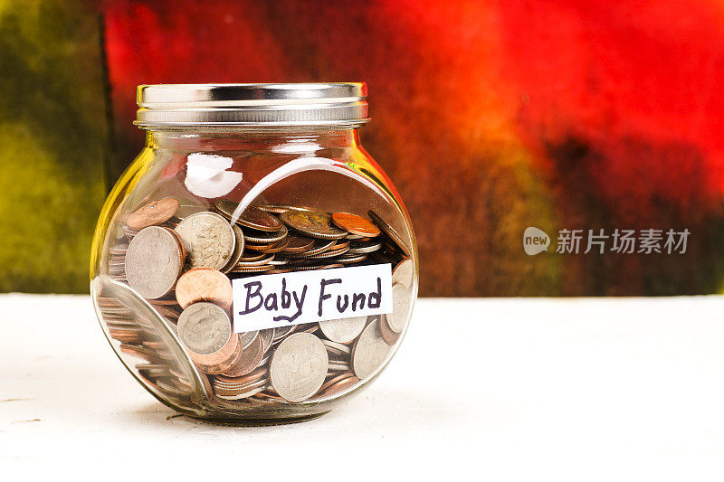 装满硬币的罐子上的婴儿基金标签