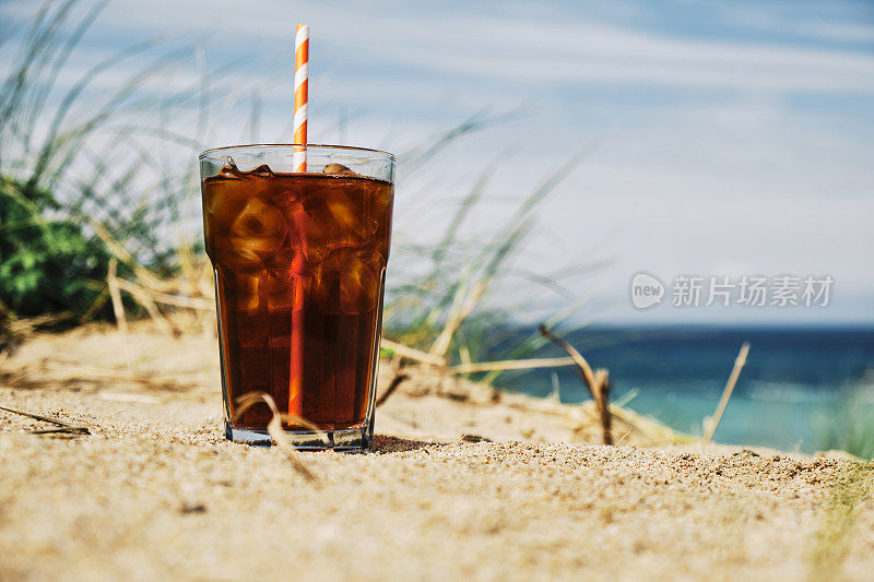 在一个炎热阳光明媚的夏日，在纽基菲斯特拉海滩的沙丘上喝一杯冰黑咖啡。