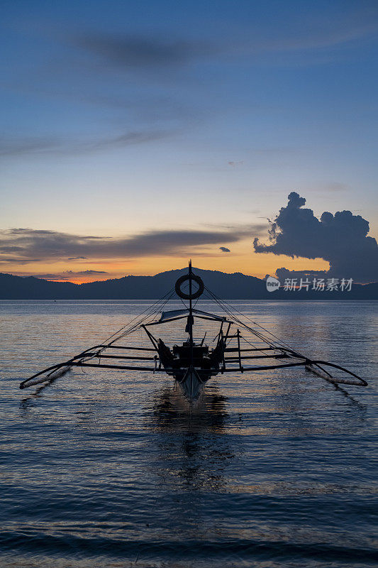 日落时分，菲律宾巴拉望巴顿港的一艘船