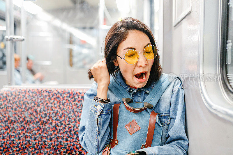 瞌睡女人在火车或地铁打哈欠，失眠和失眠的概念