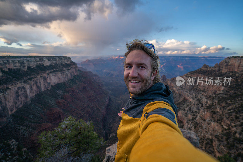 一名年轻人在美国大峡谷自拍，人们在探索大自然。男人徒步旅行