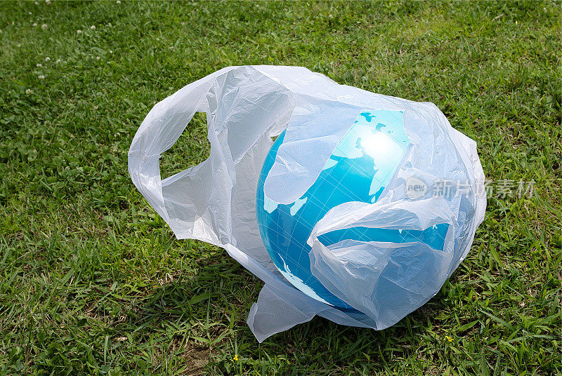废弃的塑料购物袋。里面是一个绘有世界地图的弹力球。环境污染的微塑料图像。