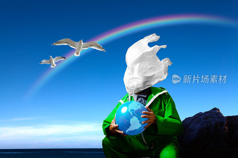 一个穿着绿色雨衣的渔民的脸上贴着一个塑料购物袋。一个超现实的微塑料环境污染和海洋污染的形象。
