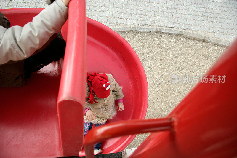 快乐的小弟弟和小妹妹在儿童游乐场玩滑梯