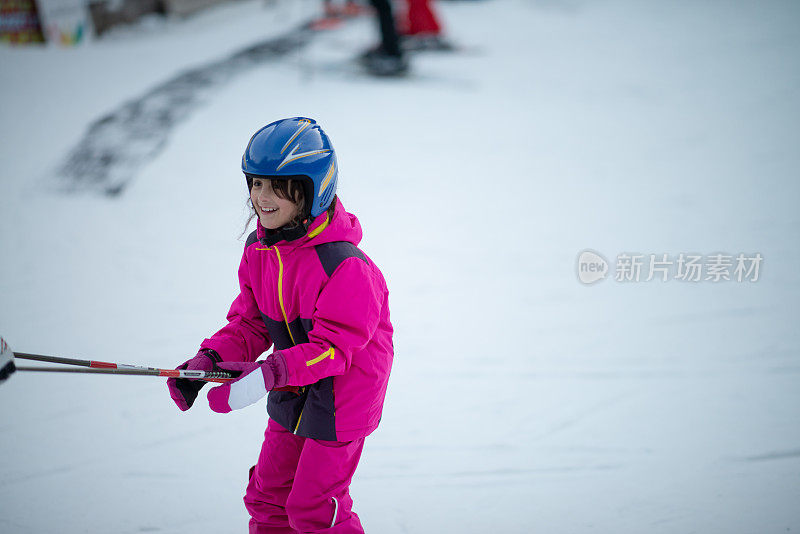 凉爽的假期。冬天的假期。快乐的小女孩滑雪课上