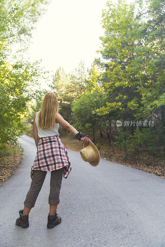 一个年轻漂亮的金发女人的肖像在路上搭便车