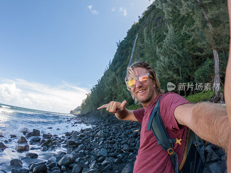 夏威夷，一名徒步男子与山谷瀑布和大海自拍