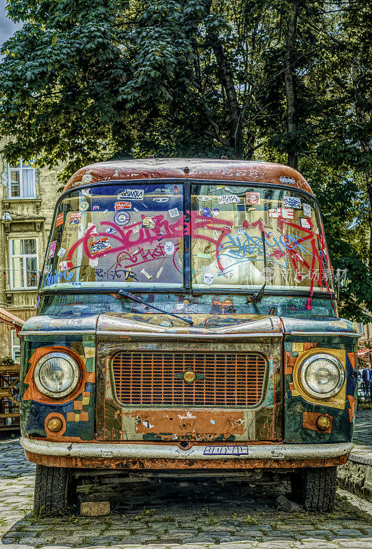 在欧洲城市利沃夫的街道上，旧的明亮装饰的小型公共汽车