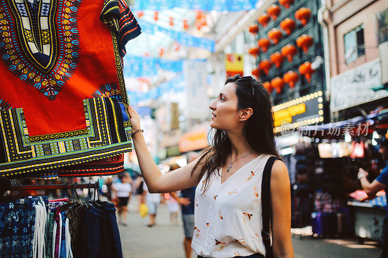 年轻的旅行者女人在吉隆坡唐人街区购物