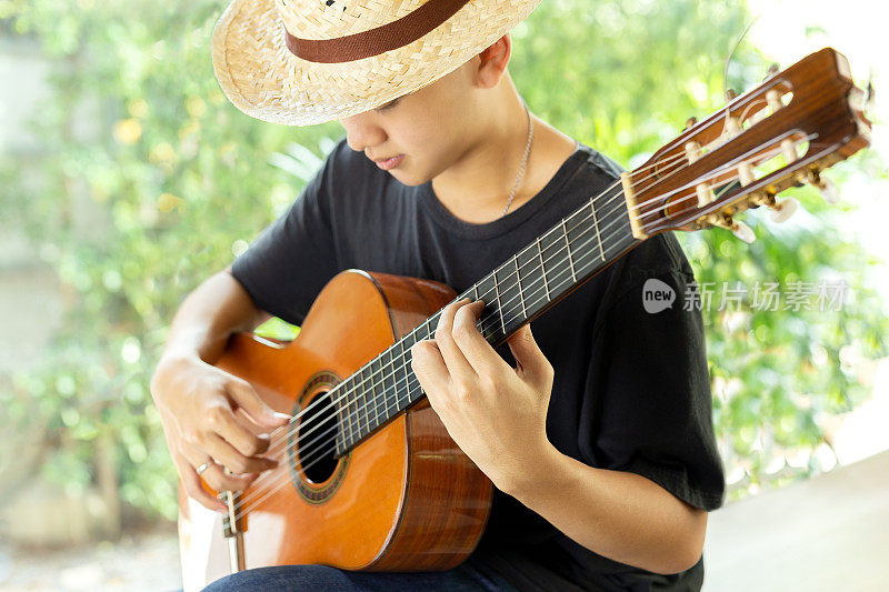 亚洲人在大自然中弹奏古典吉他。