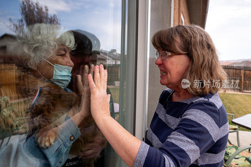 女儿探望被隔离的母亲，防止通过窗户感染冠状病毒
