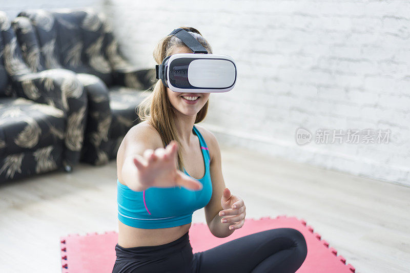 一个穿着运动服的漂亮年轻女子使用VR眼镜。