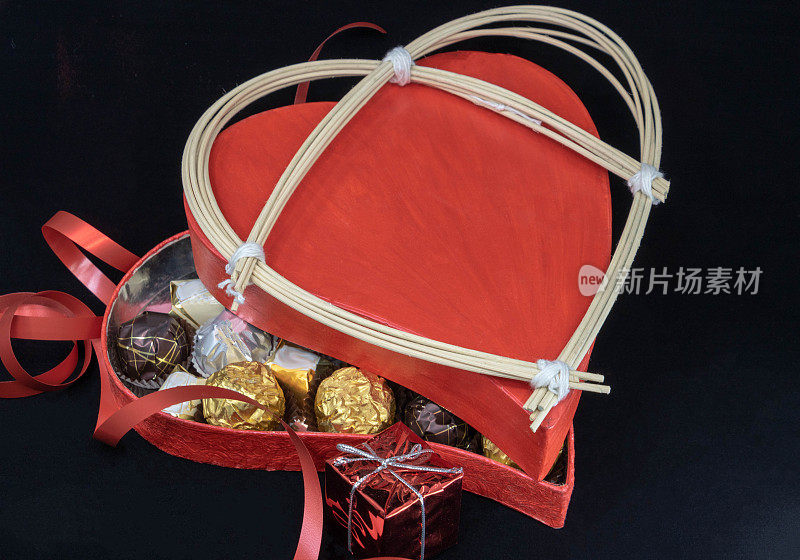 心形巧克力盒，热情的红色，半掩的巧克力和藤心