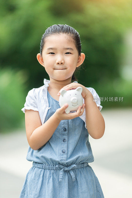 抱着存钱罐的可爱女孩