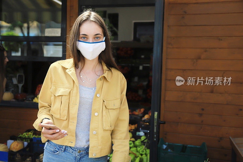 年轻女子在当地的一个市场边吃水果