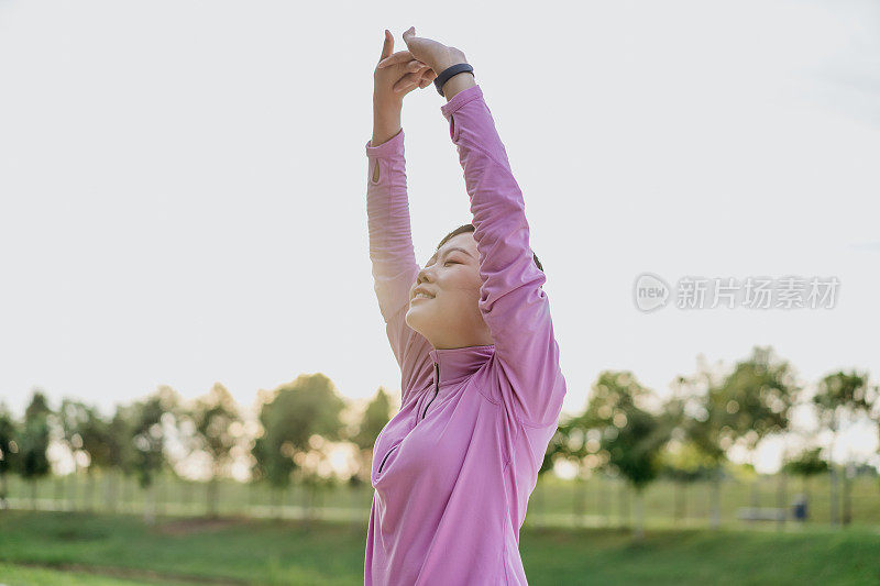 运动的年轻亚洲女人在慢跑和跑步前热身