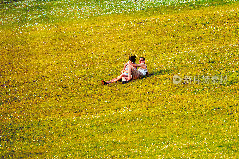 一对中年印度夫妇躺在加拿大蒙特利尔皇家山公园的草地上休息