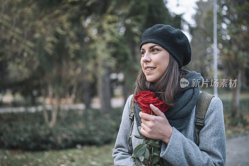 微笑的女人的肖像与一束红玫瑰。