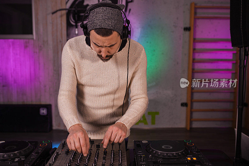 DJ在DJ控制台播放和混音音乐