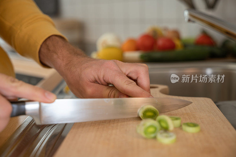 男人在厨房的木板上切菜