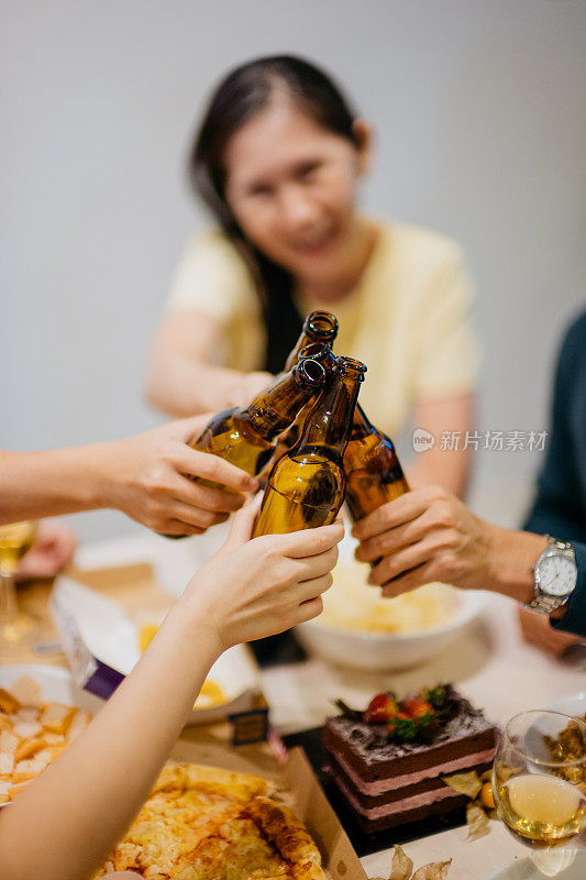 快乐的亚洲男人和女人敲着啤酒瓶