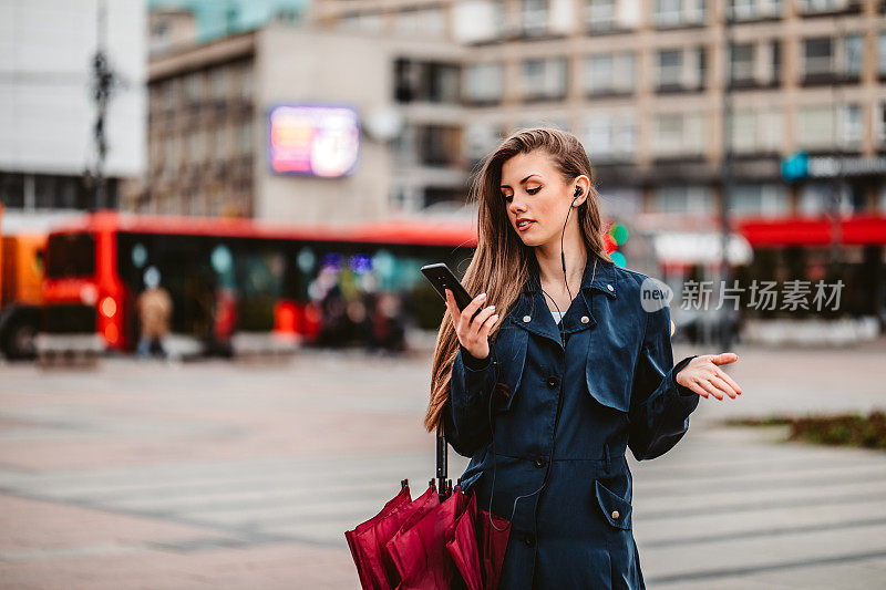 在户外戴着耳机打电话的漂亮女人